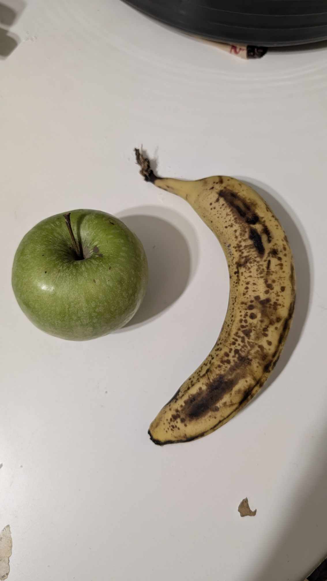 Image of a granny smith apple and a precarious looking banana